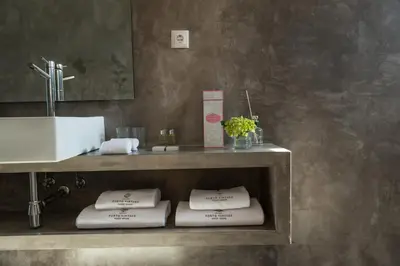 a bathroom with a sink and a shelf with towels at Porto Vintage Guesthouse in Porto