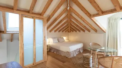 a bedroom with a bed and a table in a room at New 3BR w Rooftop & Balcony Views by LovelyStay in Porto