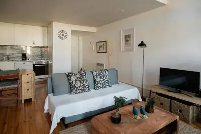 a living room with a bed and a kitchen at Downtown Urban Nest in Porto