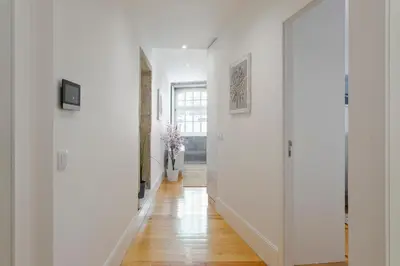 a hallway with white walls and a wooden floor at HostWise - Stylish Retreat in Porto's Heart in Porto