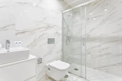 a white bathroom with a shower and a toilet at HostWise - Stylish Retreat in Porto's Heart in Porto