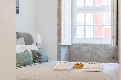 a bed with two towels and a tray of fruit on it at HostWise - Stylish Retreat in Porto's Heart in Porto