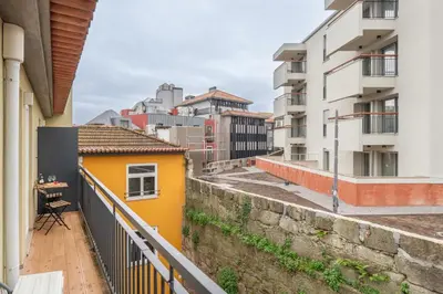 a balcony with a yellow house and buildings at HostWise - Stylish Retreat in Porto's Heart in Porto