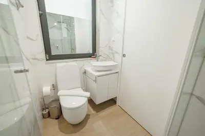 a bathroom with a toilet and a sink and a mirror at Carmo Residence Porto by Vacationy in Porto