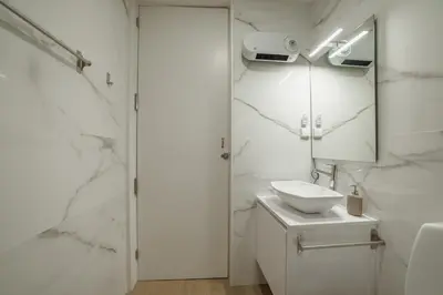 a white bathroom with a sink and a mirror at Carmo Residence Porto by Vacationy in Porto