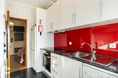 a red kitchen with a sink and a counter top at GuestReady - Bonfim Cozy Retreat in Porto