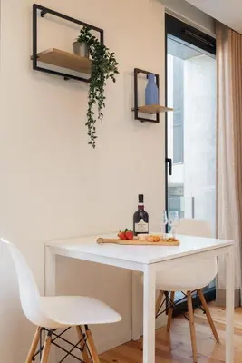 a white dining room table with two white chairs at Stylish Studio in Porto Downtown by HostWise in Porto