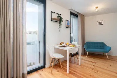 a dining room with a white table and a blue chair at Stylish Studio in Porto Downtown by HostWise in Porto
