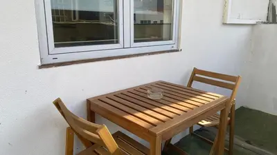 a wooden table and two chairs next to a window at BEST - Studio Trindade with AC and Parking in Porto
