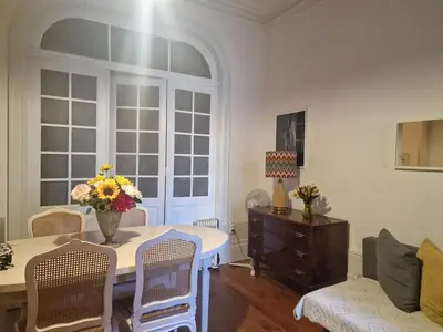 a living room with a table with a vase of flowers on it at Downtown Classic Apartment in Porto