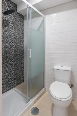 a bathroom with a toilet and a glass shower at HostWise - Artistic Escape with Modern Comfort in Vila Nova de Gaia