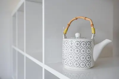 a white tea kettle sitting on a shelf at GuestReady - Mandariam Studio in Porto