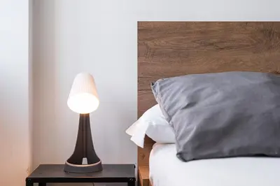 a lamp sitting on a table next to a bed at GuestReady - Mandariam Studio in Porto
