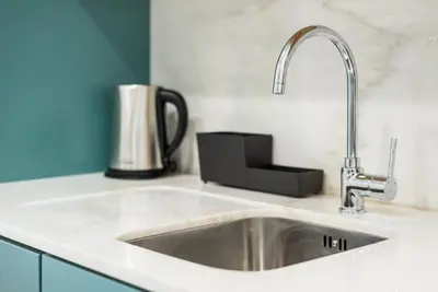 a kitchen sink with a faucet on a counter at GuestReady - Visconde Mezzanine in Porto