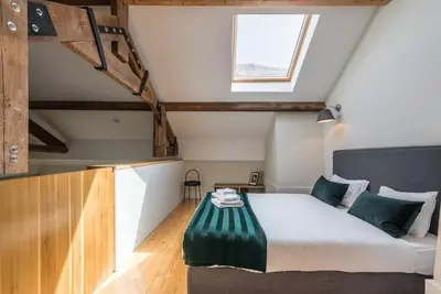 a attic bedroom with a bed and a window at GuestReady - Visconde Mezzanine in Porto