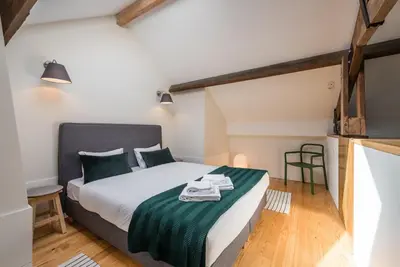 a bedroom with a bed with a green and white blanket at GuestReady - Visconde Mezzanine in Porto