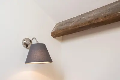 a lamp hanging on a wall next to a wooden beam at GuestReady - Visconde Mezzanine in Porto