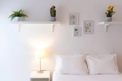 a bedroom with white walls and a bed with white pillows at Botanic Jungle at Porto Downtown in Porto
