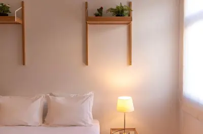 a bedroom with a bed with white pillows and a lamp at Botanic Jungle at Porto Downtown in Porto