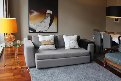 a living room with a gray couch with pillows at Porto with History in Porto