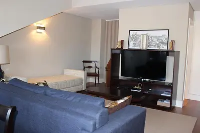 a living room with a blue couch and a flat screen tv at Porto with History in Porto