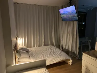 a bedroom with a bed with a television above it at Trindade Studio by Portomosa in Porto