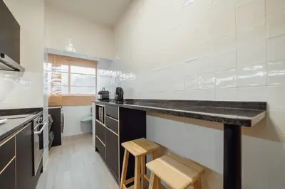 a kitchen with a counter and some stools in it at Good Morning Torrinha by Vacationy in Porto