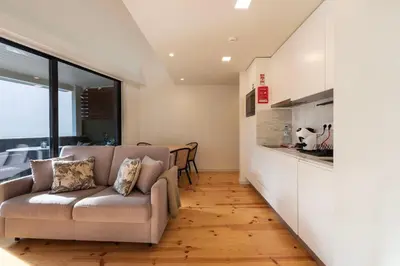 a living room with a couch and a kitchen at Porto Luxe Stay with shared Pool and Garden in Porto