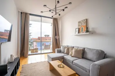a living room with a couch and a large window at Chic 1BR in República w Balcony by LovelyStay in Porto