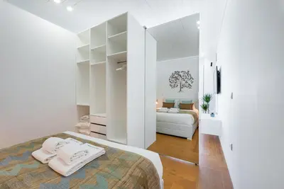 a white bedroom with a bed and a couch at GuestReady - The Citrus Glaze at the Terrace in Porto