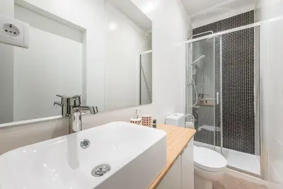 a white bathroom with a sink and a toilet at GuestReady - Fabric in Colors in Porto