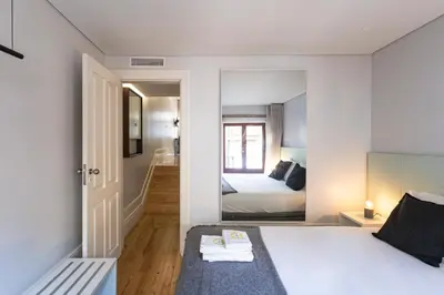 a bedroom with a bed and a mirror at ApartmentsPorto - Rua de Trás 156 in Porto