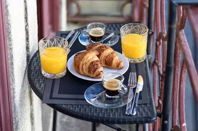 a table with a plate of bread and glasses of orange juice at ApartmentsPorto - Rua de Trás 156 in Porto