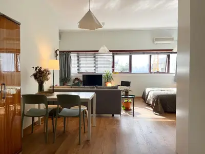 a living room with a dining room table and a bedroom at Casa Sophia in Porto