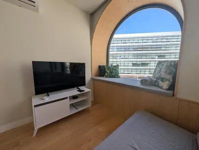a bedroom with a chair and a large window at Charming apartment frente in Porto