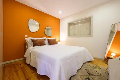 a bedroom with a large white bed and two mirrors at GuestReady - Hope Apartments in Porto
