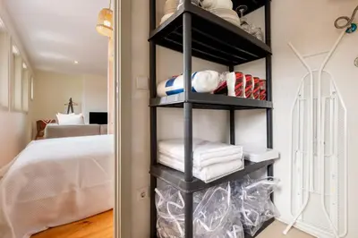 a black shelving unit in a bedroom with a bed at GuestReady - Hope Apartments in Porto