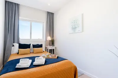 a bedroom with a bed with two towels on it at Bright & Spacious Retreat with Balcony by HostWise in Porto