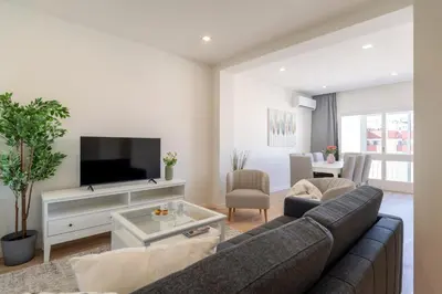 a living room with a couch and a tv at Bright & Spacious Retreat with Balcony by HostWise in Porto