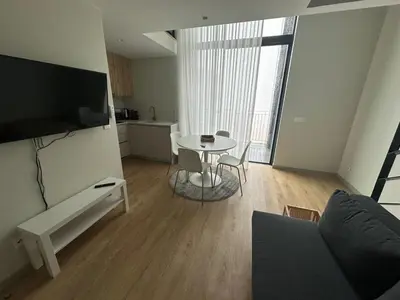 a living room with a table and a couch and a kitchen at NEW Douro 901 Mezzanini with parking in Vila Nova de Gaia