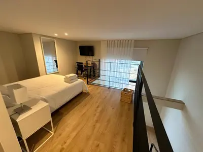 a bedroom with a large bed and a balcony at NEW Douro 901 Mezzanini with parking in Vila Nova de Gaia