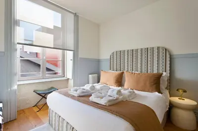 a bedroom with a bed with towels on it at BOUTiQUE Rentals- THE MiRaDOURO Ribeira Apartment in Porto
