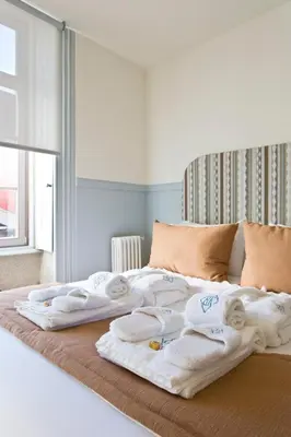 a bed with towels sitting on top of it at BOUTiQUE Rentals- THE MiRaDOURO Ribeira Apartment in Porto