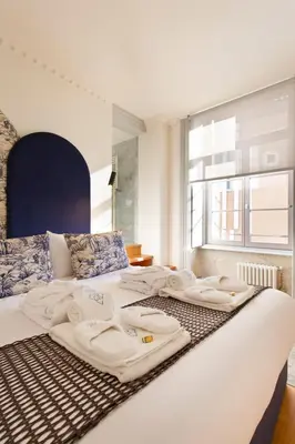 a bedroom with a bed with towels on it at BOUTiQUE Rentals- THE MiRaDOURO Ribeira Apartment in Porto