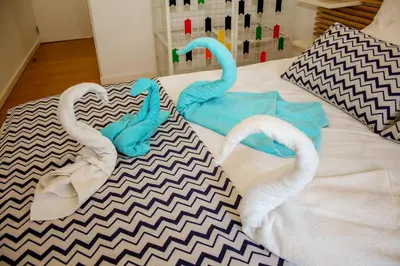 two towels on a bed with swans on it at T3 suites com vistas rio Douro in Vila Nova de Gaia