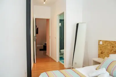 a bedroom with a bed and a mirror and a bathroom at T3 suites com vistas rio Douro in Vila Nova de Gaia