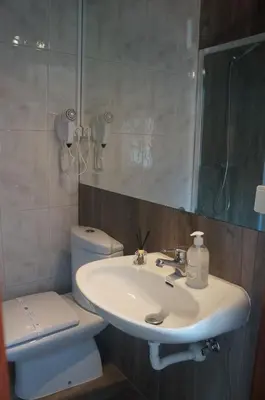 a bathroom with a sink and a toilet and a mirror at Casa no centro histórico in Vila Nova de Gaia