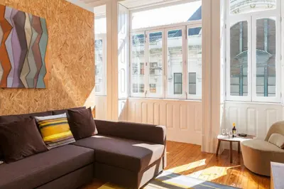 a living room with a couch and some windows at BO - Sá da Bandeira in Porto