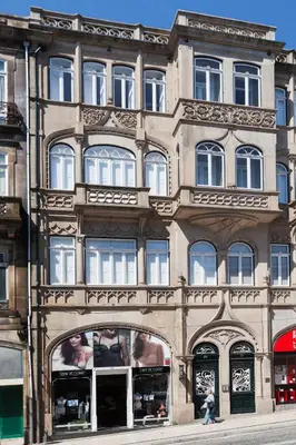a large building with windows on a city street at BO - Sá da Bandeira in Porto