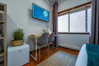 a bedroom with a desk and a tv on the wall at Oporto Center at Your Doorstep 1 in Porto